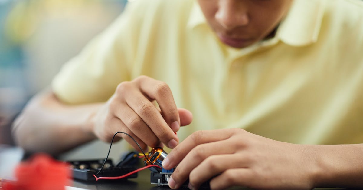 Fixing oily dukkah - Boy Fixing an Electronic Device