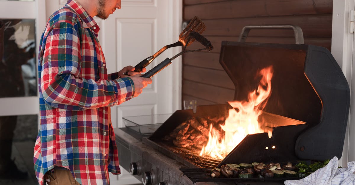 Flames into cooking area - Man in Red and Blue Plaid Dress Shirt Holding Knife and Fork