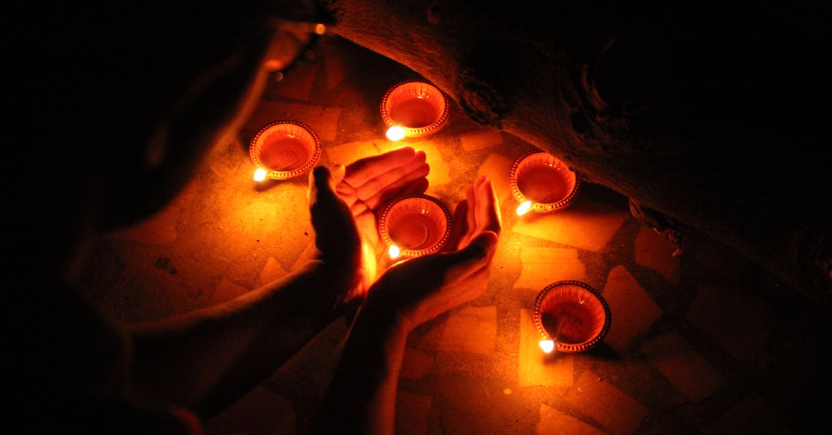 flash fire from self-cleaning oven - From above crop anonymous person burning candles and standing with candleholder between hands in darkness