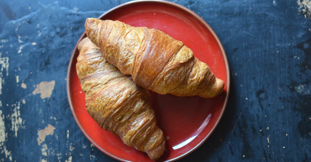 Flatbread dough turned red - Delicious croissants on plate on table