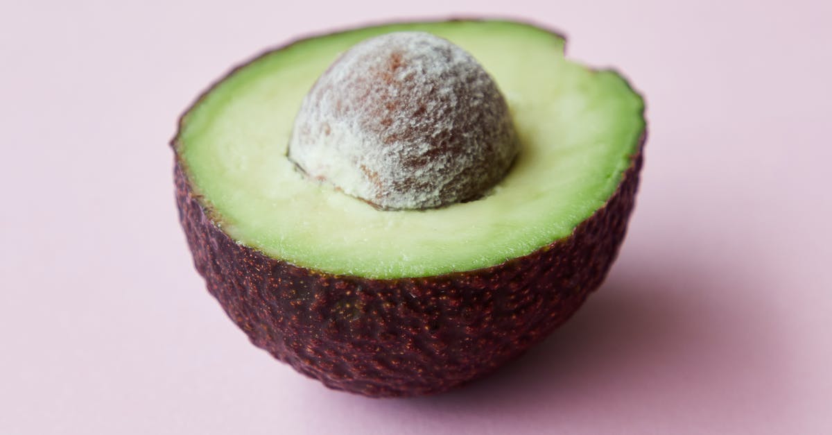 Flavor in avocadoes gone forever? - High angle of half of fresh ripe avocado with seed on purple background