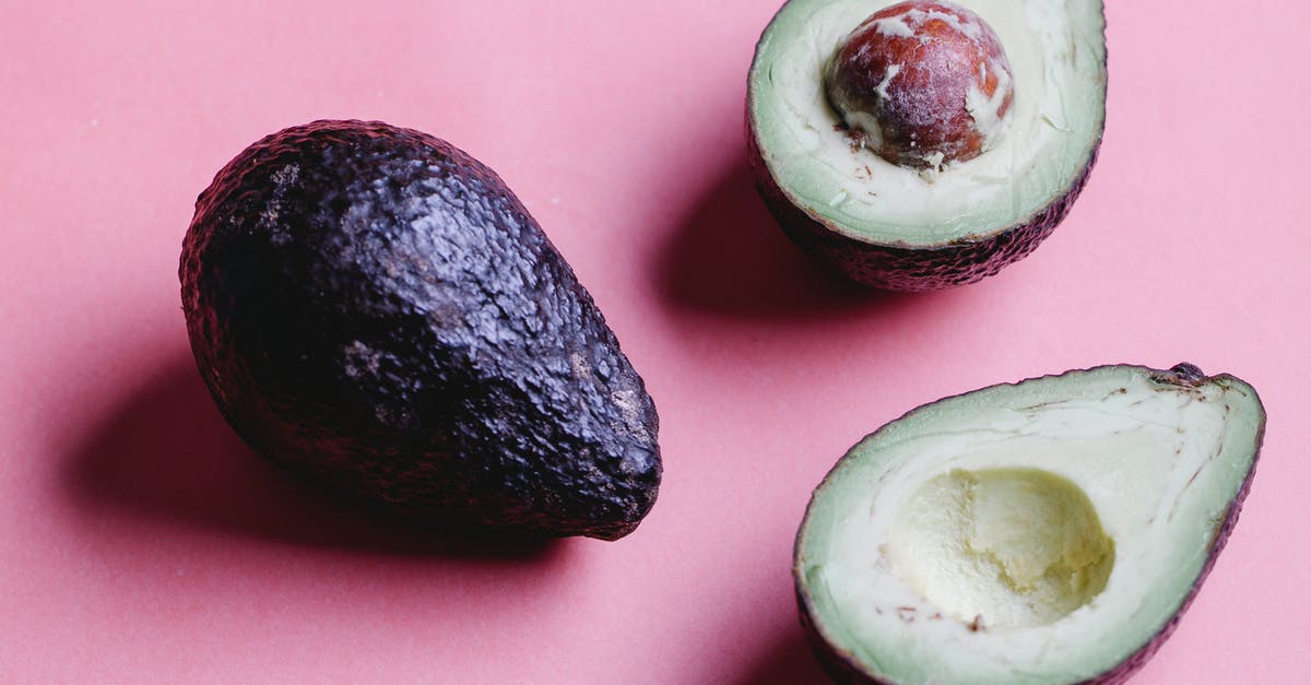 Flavor in avocadoes gone forever? - Composition of halved avocados on pink background