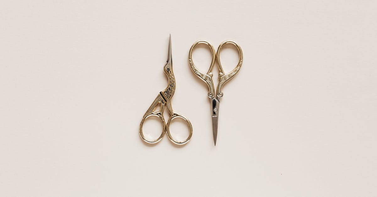 Flavour in different cuts - Top view composition of scissors of various shape with carved ornament on beige table