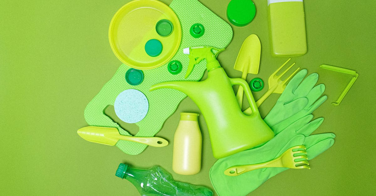 Flavour in different cuts - Top view monochrome of various plastic bottles and kitchen utensil polluting planet on green background