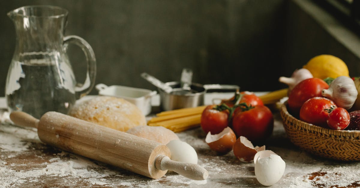 Flour and water... at which temperature? - Assorted vegetables in wicker basket near rolling pin and eggshells on table with spilled flour at home