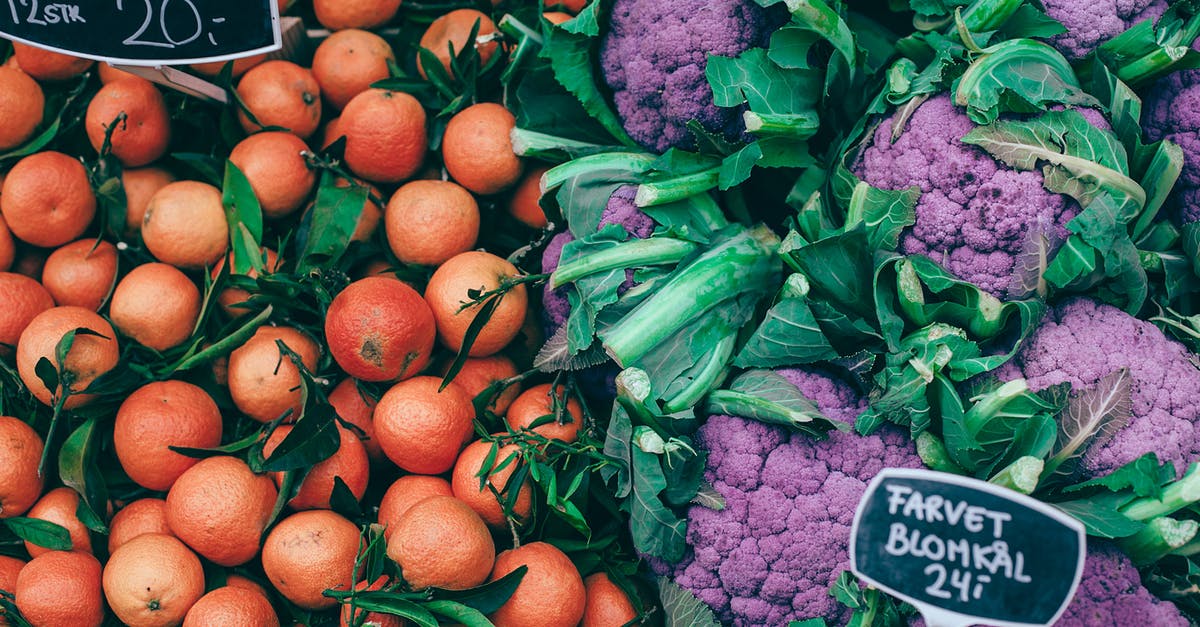 Food grade lye on counter tops - From above of fresh ripe colorful citrus fruits placed near violet healthy cauliflower on market