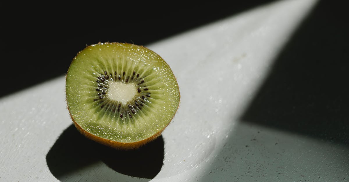 Food is still undercooked on cast iron - Half of fresh juicy kiwi at sunshine