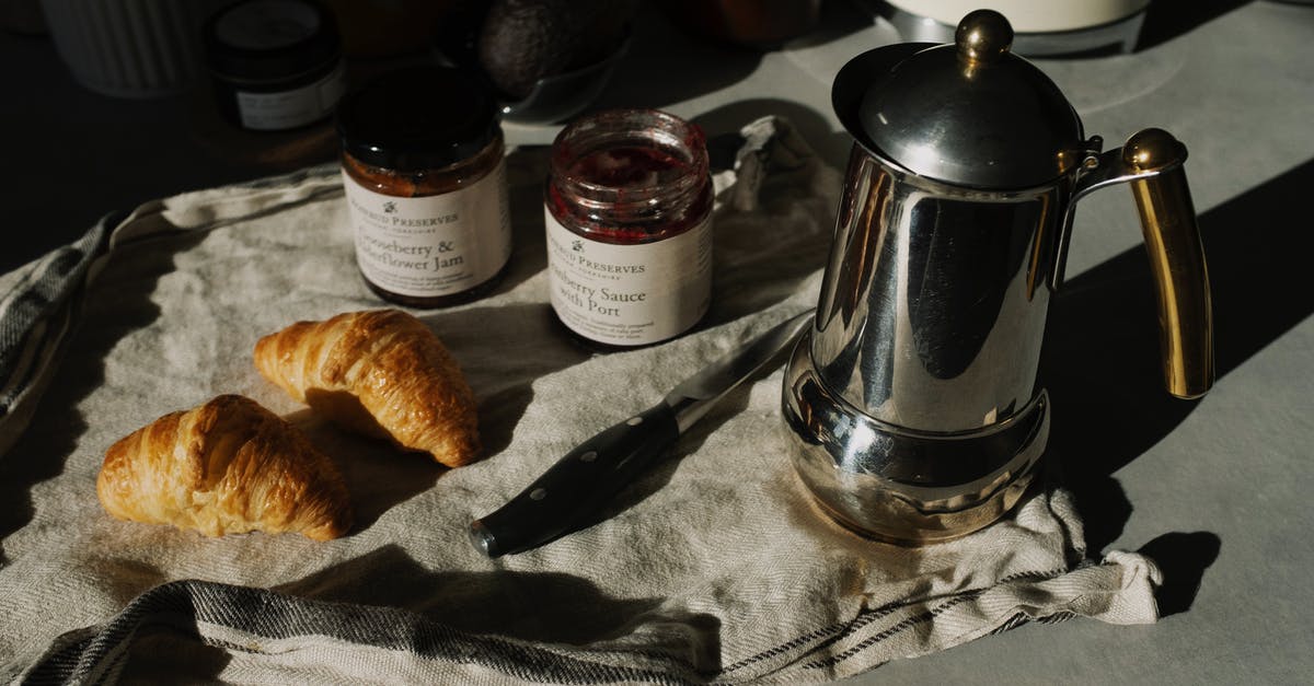 Food mills versus food strainer/sauce makers - Stainless Steel Teapot Beside Bread Knife and Bread on White Table