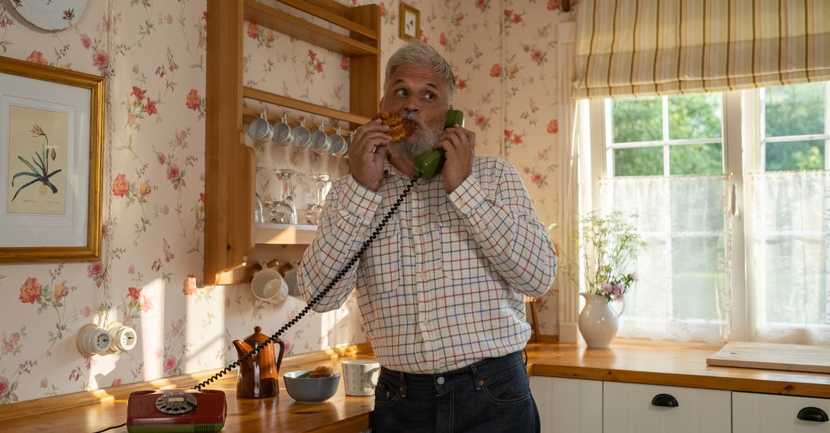 Food-safe rotary evaporator grease - Senior Man Talking on Landline Phone and Eating Cinnamon Bun in Old-Fashioned Kitchen