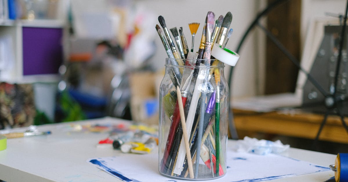 For Pressure Canning, can I use any other jar than Ball’s Mason Jar? - Glass jar with paintbrushes on desk with paint tubes in professional art workshop