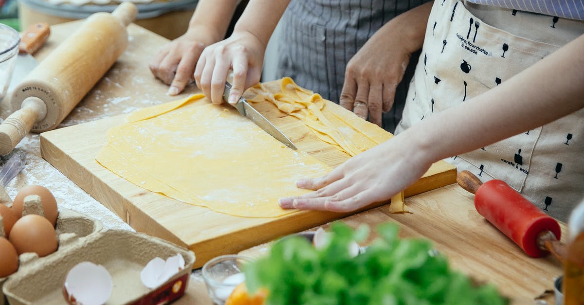 For reheating stuffing in the oven, how long would you bake it and at what temperature? - Women making homemade pasta in kitchen
