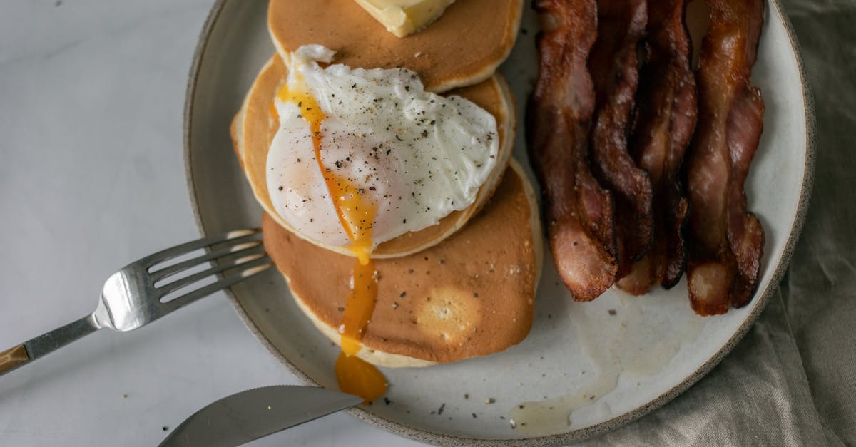 Forgotten Fried Eggs Recipe - Plate with pancakes with butter near poached egg and roasted bacon