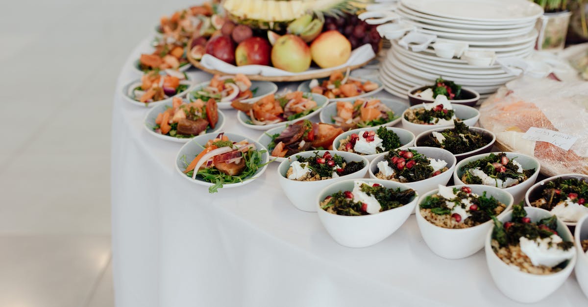 Forties dinner buffet - Bowls with bulgur and salads with fish served on white table with dishware and various ripe fruits during festive event
