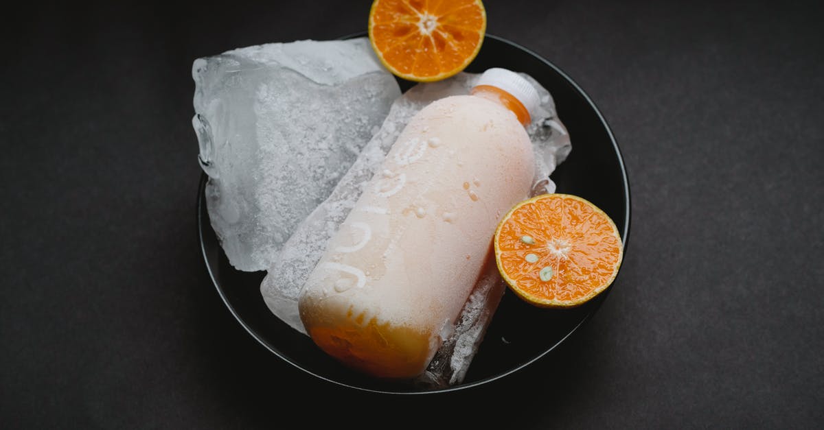 Freezing fresh juices - Bottle with orange juice on plate