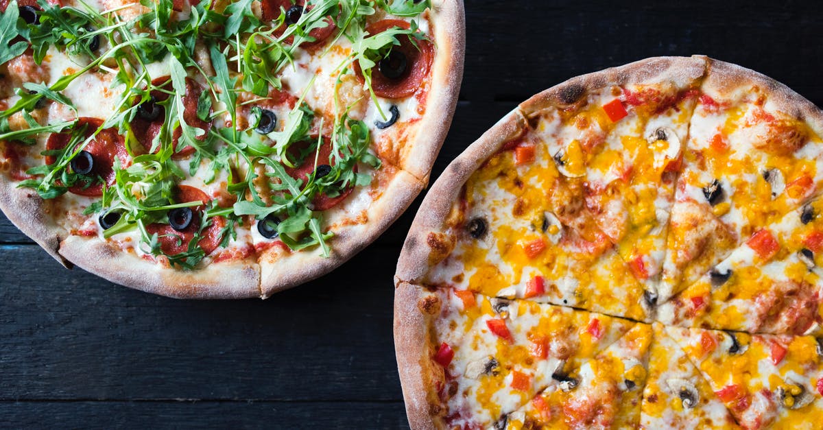 Freezing meat - whole or in pieces? - Overhead view of delicious pizzas with mushroom and pepperoni pieces under fresh herb leaves on dark background