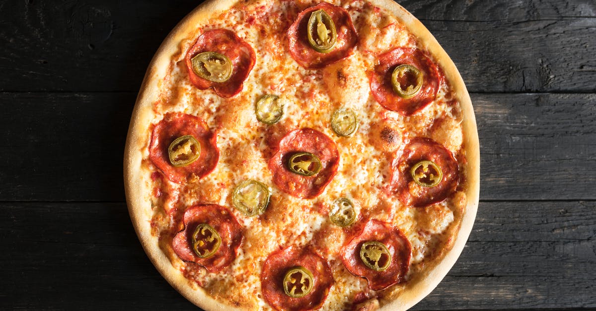 Freezing meat - whole or in pieces? - Overhead view of appetizing pizza with pepperoni and green chili pepper pieces on wooden surface