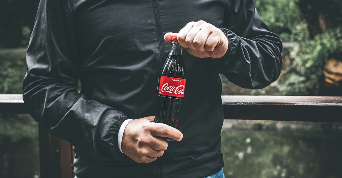 Freezing temp of carbonated beverages - Man in Black Jacket Holding Bottle of Coca-cola