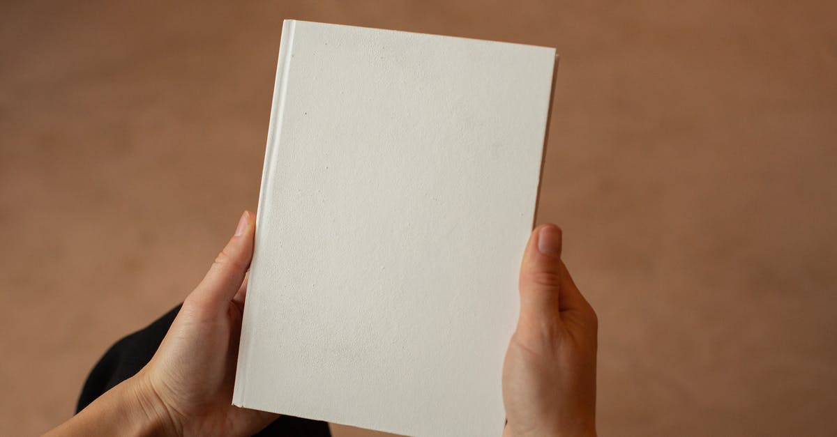 French (?) pastry on the cover of a book - Person holding hardcover book with blank cover