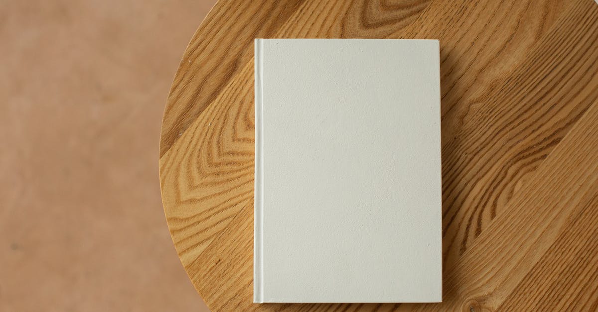 French (?) pastry on the cover of a book - Empty white book on wooden table