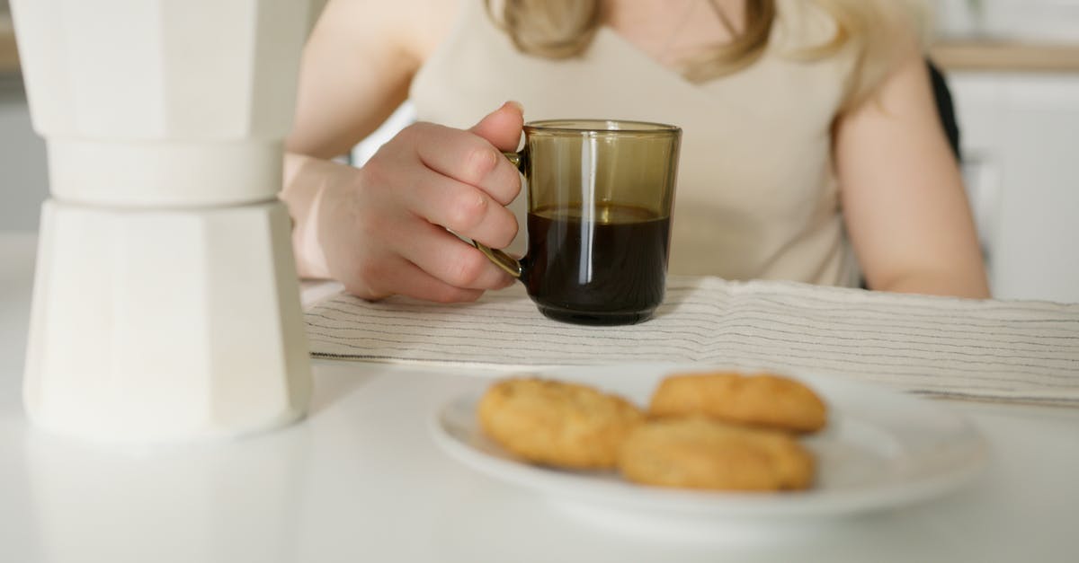 Fresh milk curdles when added to hot coffee and tea - Person Holding Clear Drinking Glass With Black Liquid