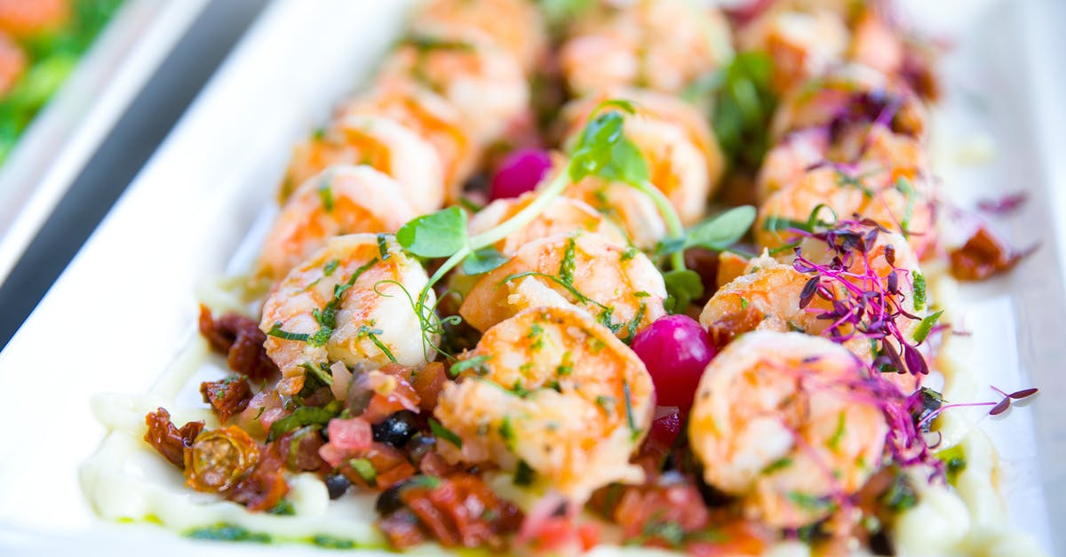 Fresh popcorn serving size suggestion [closed] - Closeup of delicious shrimps with vegetables and microgreens on white plate on catering table