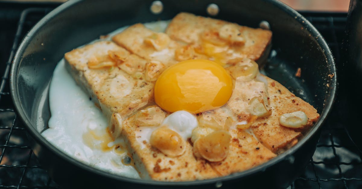 Fried garlic turning black - High angle tasty homemade egg toasts on pan roasting on barbecue grid in backyard