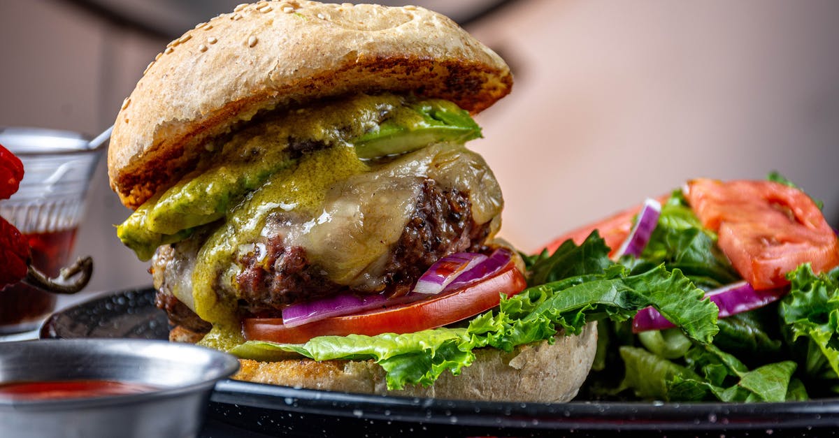 Frozen raw beef patties vs cooked refrigerated patties? - Burger With Lettuce and Tomato on Black Ceramic Plate