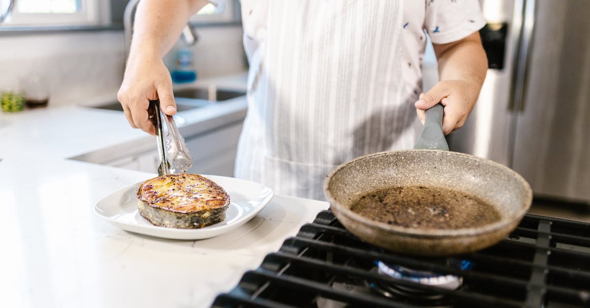 Frying fish without it falling to shambles [duplicate] - Cook Putting Portion of Ready Fried Salmon Slice on Plate