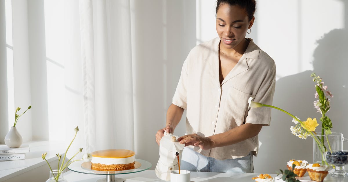 Ganache by pouring before fondanting a cake - Woman Pouring Coffee Drink on a Ceramic Cup 