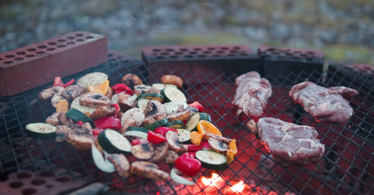 Gas grill flames very high cooking chicked wings and vegetables - Grilling Meat and Vegetable Outdoor