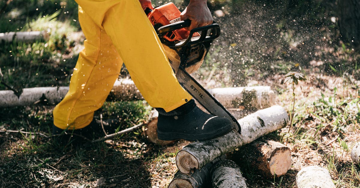 gas range hack for greater power output: does it work? - Lower body of crop unrecognizable woodcutter in yellow protective workwear cutting woods with powerful modern chainsaw while working in forest on sunny day
