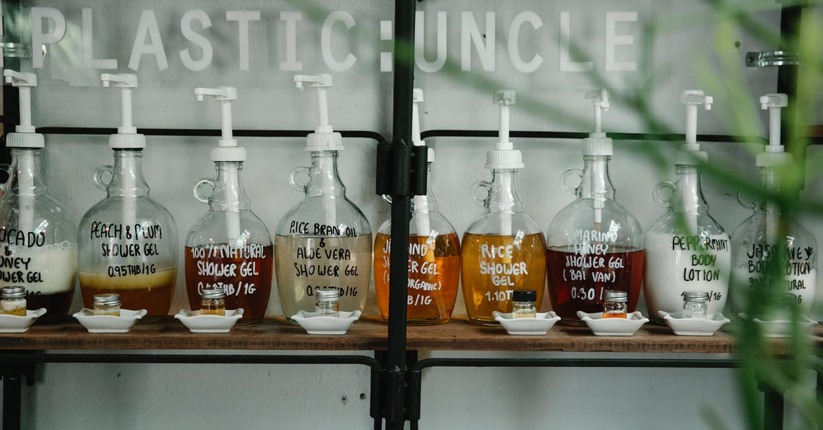 gel substance to keep food moist? - Raw of dispensers with multicolored shower gel and lotion placed near glass jars in white saucers on wooden shelf