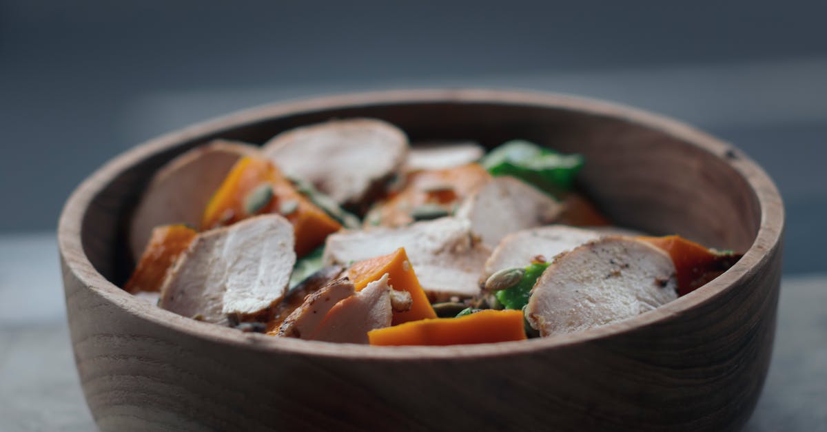 Getting flavor into chicken - From above of appetizing salad with thin chicken slices and vegetables in wooden bowl on table