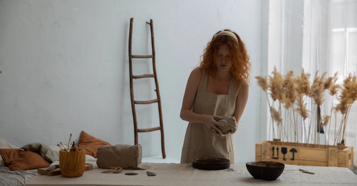 Getting the bowl out of the mold - Redhead woman working with clay