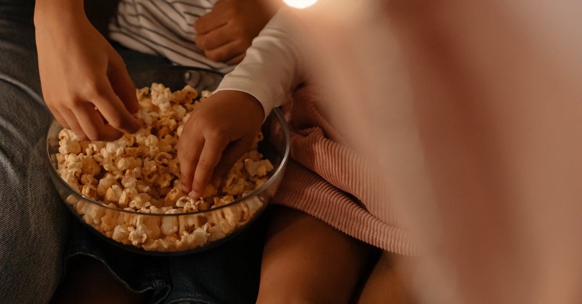 Getting the bowl out of the mold - Photograph of Kid's Hands Getting Popcorn From a Bowl