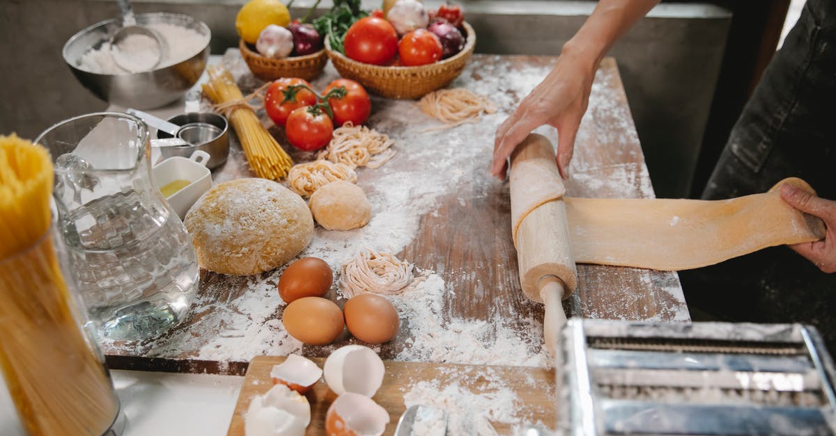 GF Wonton/Dumpling wrapper tip from pintrest (lasagna noodle + egg) - Person rolling out dough with rolling pin on wooden table