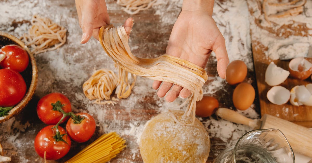 GF Wonton/Dumpling wrapper tip from pintrest (lasagna noodle + egg) - From above of crop anonymous female demonstrating long thin noodle near table with tomatoes and eggs