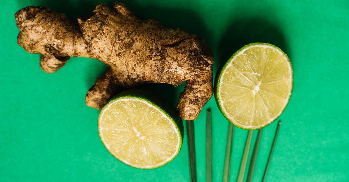 Ginger vs Ginger Root -  Ginger Root and Lime Halves on a Green Surface