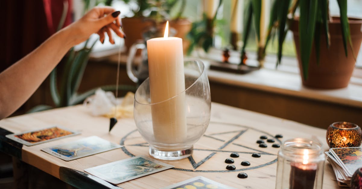 Glass bowl safe in pressure cooker? - Crop unrecognizable female fortune teller with amulet near tarot cards and shiny candles during prediction process at home