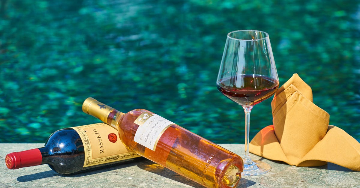 Glass still safe after boil-off? - Two Labeled  Bottles Of Wine Beside A Wine Glass By The Pool