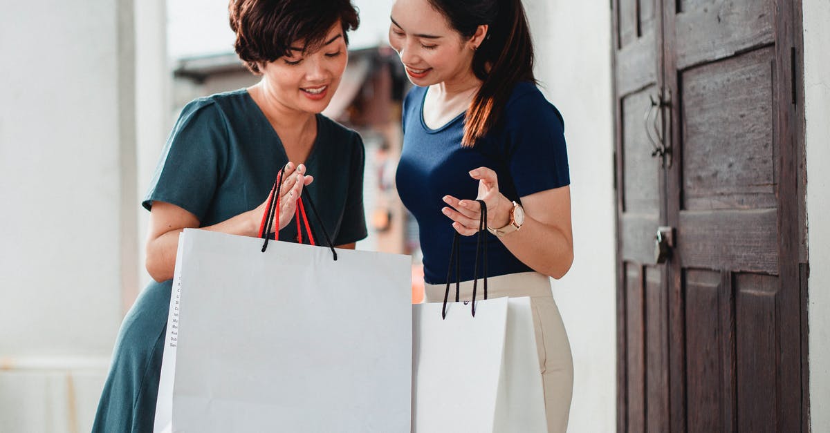 Good Idea to Buy Discount Meat For Freezing? - Happy ethnic women holding paper bags after shopping and showing purchases to each other