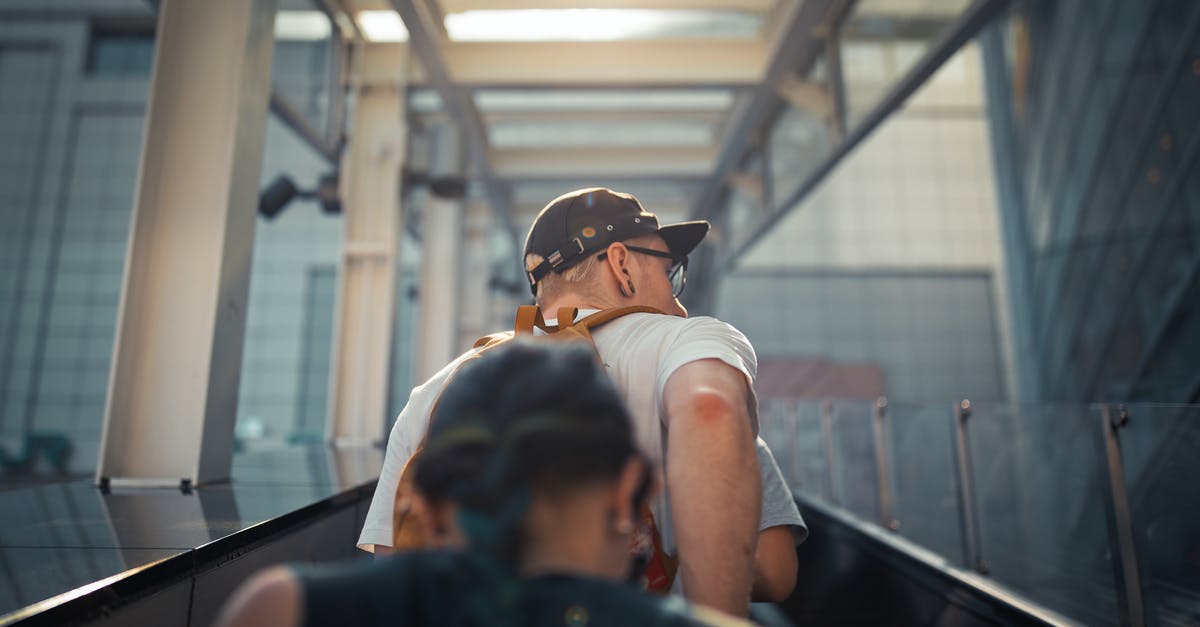 Good way to prevent grease build up in kitchen? - From below back view unrecognizable people in casual wear going up on outside escalator of modern building in daylight