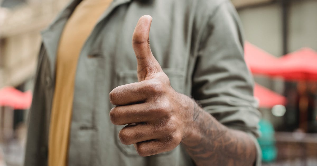 Good way to prevent grease build up in kitchen? - Crop faceless young black male in casual outfit standing on city street and showing thumb up gesture