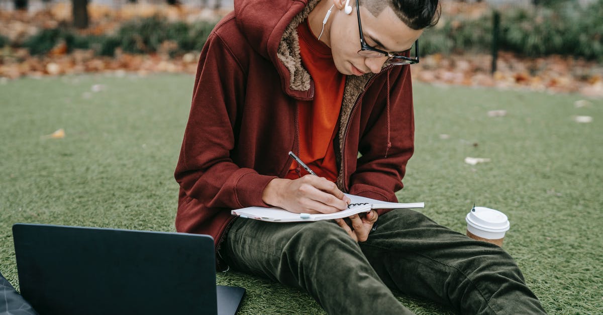 Grassy Tea and brands - Man studying with notepad and laptop on grassy lawn