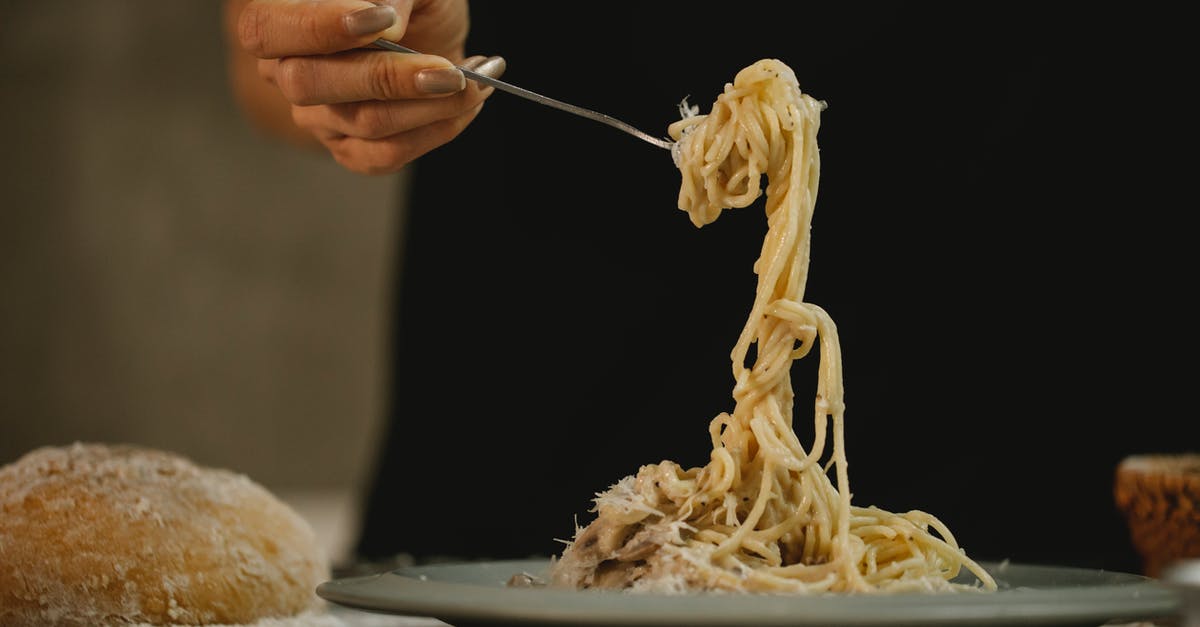 Grey mushroom cream sauce - why so dark? - Crop unrecognizable woman eating spaghetti in cream sauce