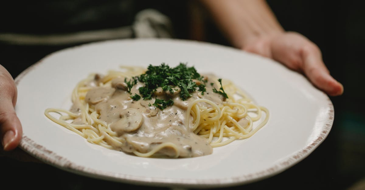 Grey mushroom cream sauce - why so dark? - Crop unrecognizable woman serving plate of scrumptious spaghetti