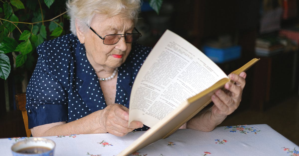 Grinding loose Green Tea for more concentration - Focused aged woman turning pages of book