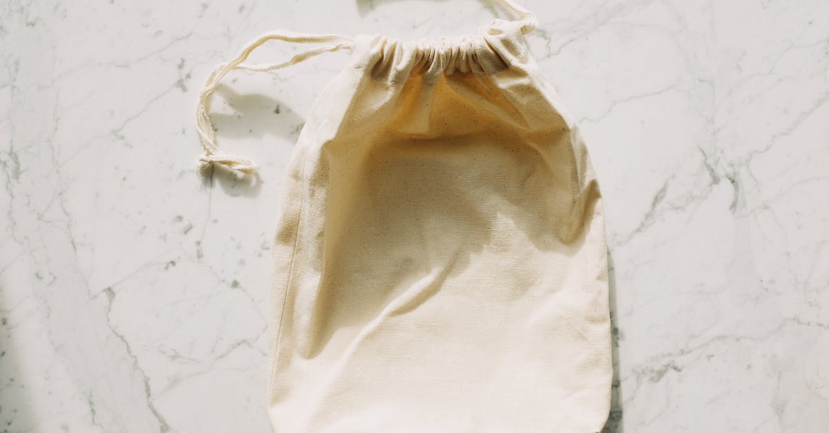 Gritty White Globules in Precooked Grocery Store Sausage? - Top view of white empty textile bag with drawstrings placed on marble table in light room Gritty White Globules in Precooked Grocery Store Sausage? - Top view of white empty textile bag with drawstrings placed on marble table in light room
