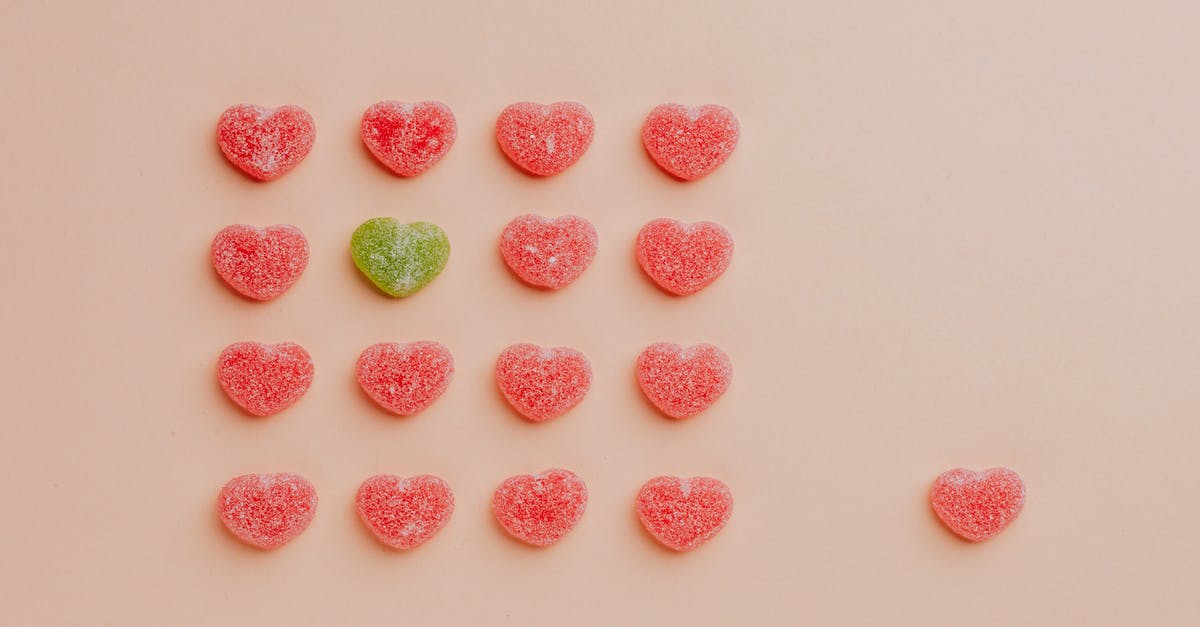 Gummy residue from baking spray/oil - Top view of delicious sprinkled jelly sweets composed in lines with one candy aside on pink backdrop in candy shop