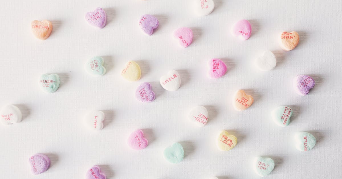 Gummy residue from baking spray/oil - Top view composition of multicolored small heart shaped sweets placed on plain white surface